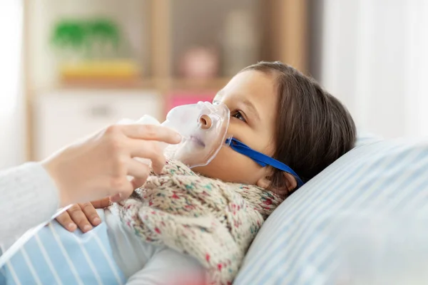 Mère et fille malade avec masque à oxygène au lit — Photo