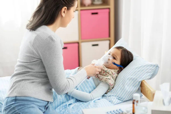 Madre e hija enferma con máscara de oxígeno en la cama — Foto de Stock