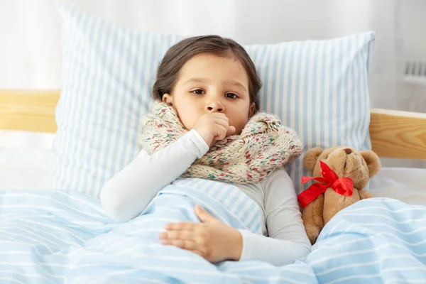 生病咳嗽的女孩躺在家里的床上 — 图库照片