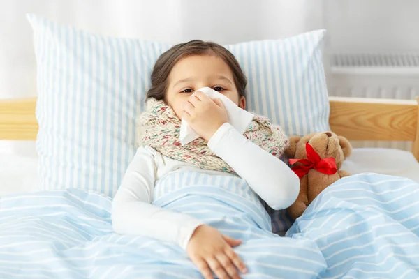 Krankes Mädchen liegt zu Hause im Bett und pustet Nase — Stockfoto