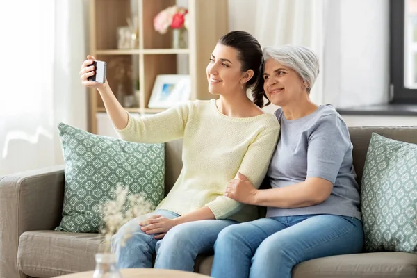 Senior mor med dotter som tar selfie hemma — Stockfoto