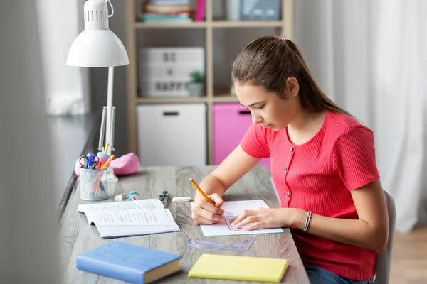 Student girl with ruler drawing line in notebook — Stock Photo, Image