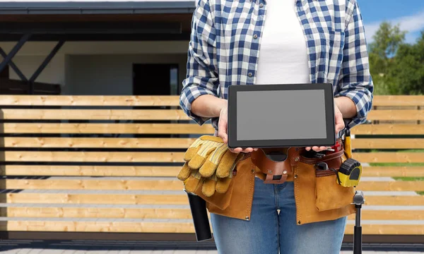 Mujer constructor con herramientas de trabajo que muestra la tableta pc — Foto de Stock