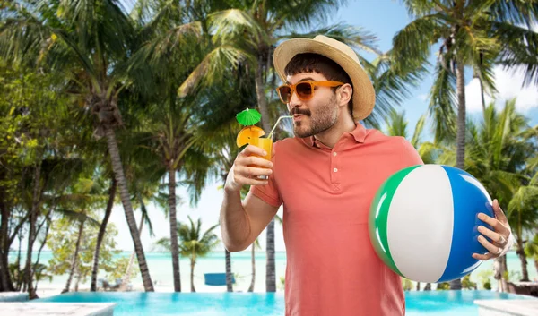 Uomo felice in cappello di paglia con succo di frutta sulla spiaggia — Foto Stock