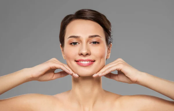 Mooie jonge vrouw aanraken van haar gezicht en kin — Stockfoto