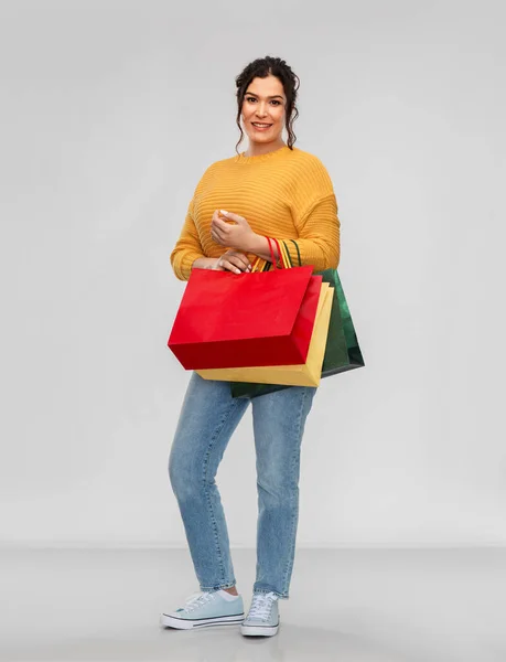 Szczęśliwa uśmiechnięta młoda kobieta z torbami na zakupy — Zdjęcie stockowe