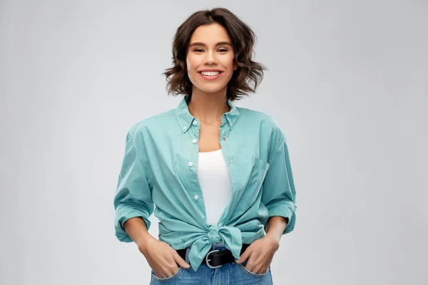 Portrait of smiling young woman in turquoise shirt — Stock Photo, Image