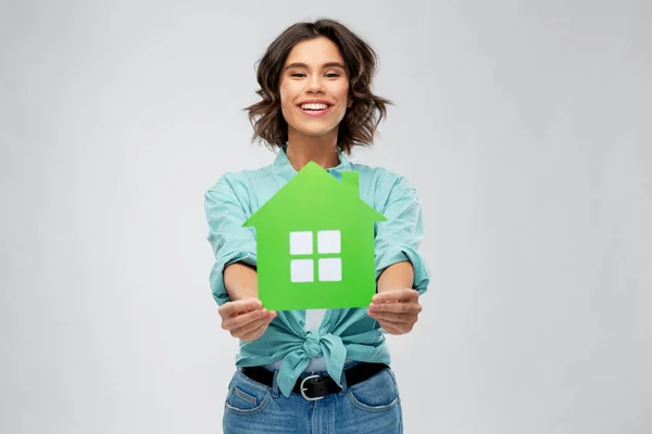 Smiling young woman holding green house — Stock Photo, Image