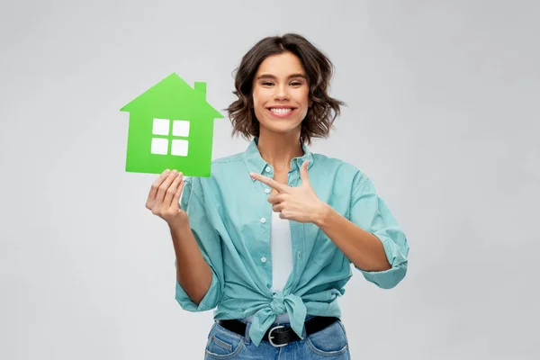 Sonriente joven mujer mostrando casa verde —  Fotos de Stock