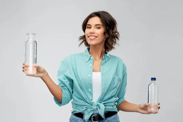 Sonriente joven mujer comparando botellas de agua — Foto de Stock