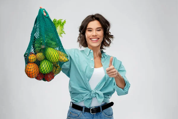 Gelukkig glimlachende vrouw met voedsel in herbruikbare nettas — Stockfoto