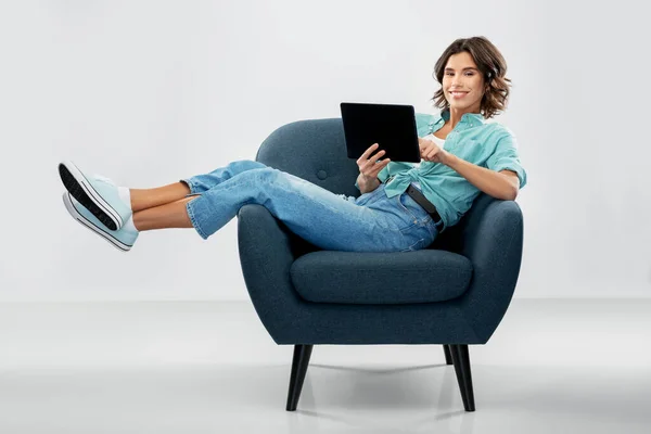 Ευτυχισμένη γυναίκα με tablet pc κάθεται στην πολυθρόνα — Φωτογραφία Αρχείου