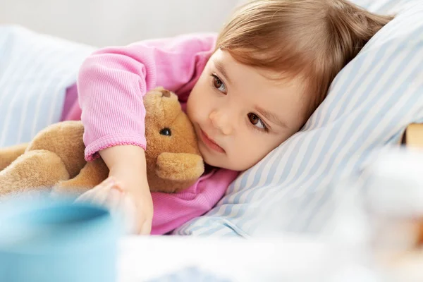 Маленька дівчинка лежить в ліжку вдома — стокове фото