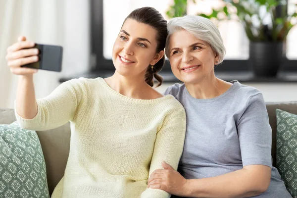 Senior moeder met dochter nemen selfie thuis — Stockfoto