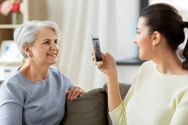 Hija adulta fotografiando a la madre mayor en casa — Foto de Stock