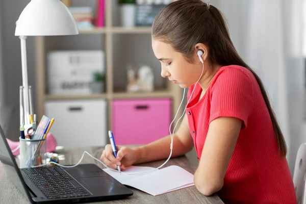 Student girl in earphones learning at home — Stock Photo, Image