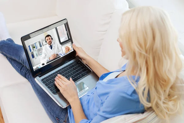 Frau telefoniert mit männlichem Arzt auf Laptop — Stockfoto