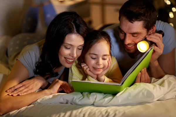 Geceleri evde yatakta mutlu aile okuma kitabı — Stok fotoğraf