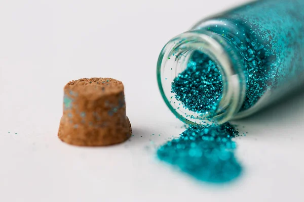 Blått glitter hälls från små glasflaska — Stockfoto