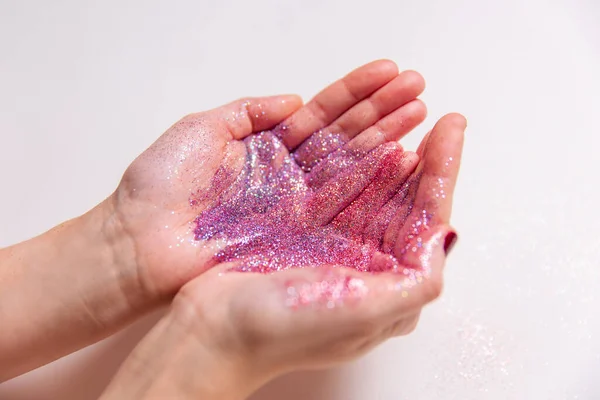 Händer som håller glitter på vit bakgrund — Stockfoto