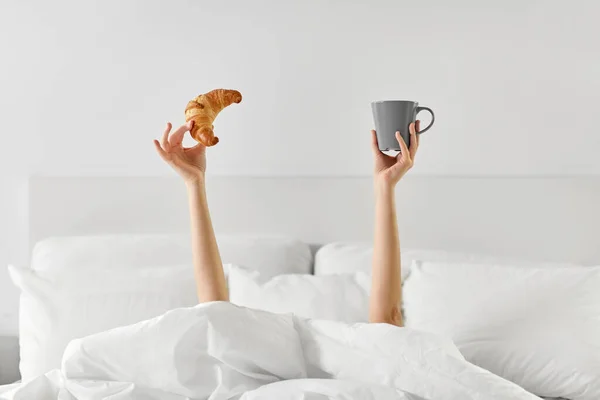 Mujer con café y croissant acostado en la cama —  Fotos de Stock