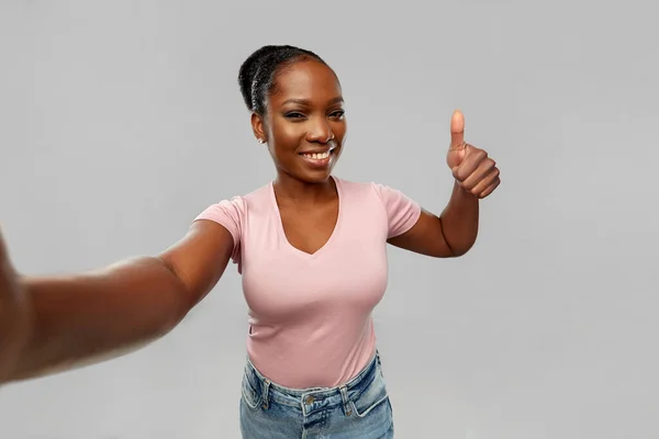 Mujer africana tomando selfie y mostrando pulgares hacia arriba — Foto de Stock