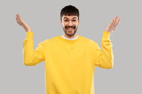 Usmívající se mladý muž ve žluté mikině — Stock fotografie