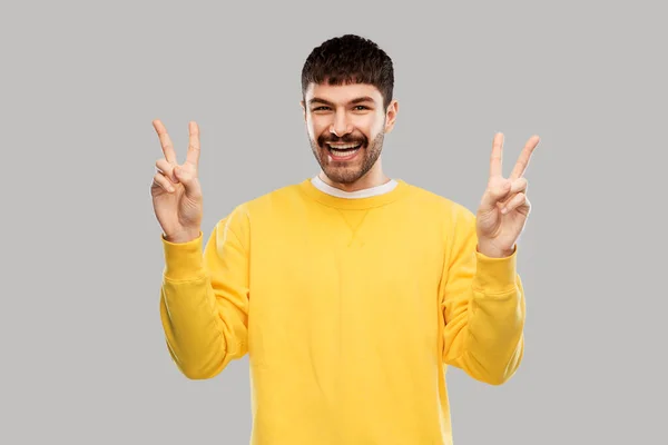 Joven mostrando paz sobre fondo gris —  Fotos de Stock