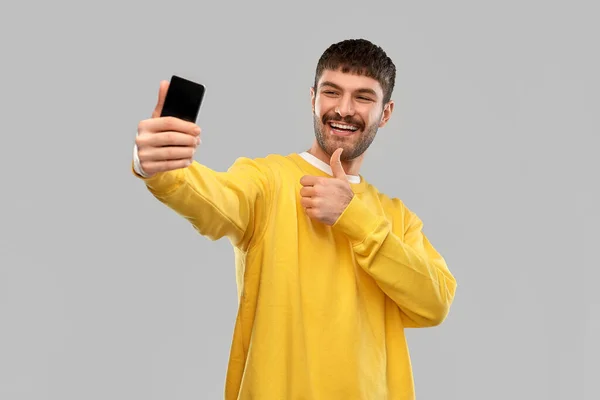 Homem leva selfie com telefone e mostra polegares para cima — Fotografia de Stock