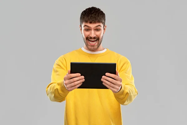 Улыбающийся молодой человек с планшетным компьютером — стоковое фото