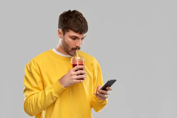 Muž s chytrým telefonem a rajčatovou šťávou — Stock fotografie