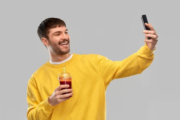 Hombre feliz con smartphone y jugo tomando selfie —  Fotos de Stock