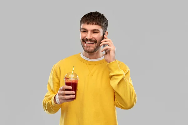 Счастливый мужчина с томатным соком звонит в смартфон — стоковое фото