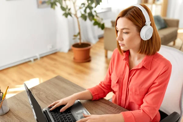 Femme dans un casque avec ordinateur portable travaillant à la maison — Photo