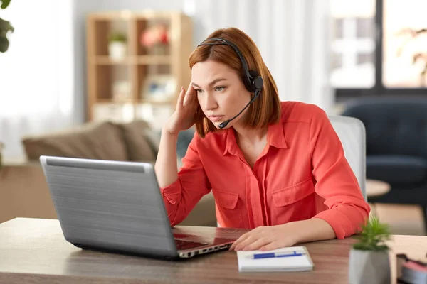 Traurige Frau mit Headset und Laptop, die zu Hause arbeitet — Stockfoto