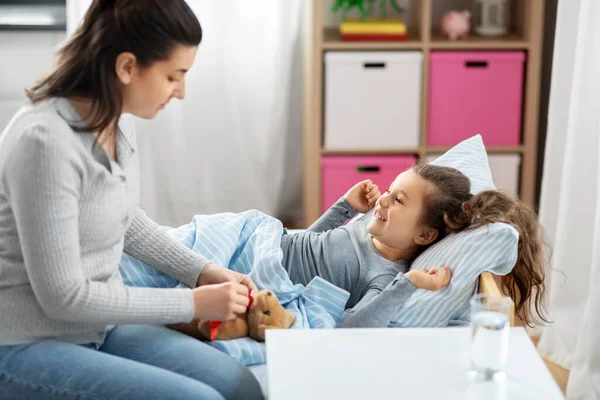 Mother and happy little daughter in bed at home — Stock Photo, Image