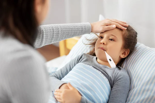 Mother and sick daughter measuring temperature — Stock Photo, Image