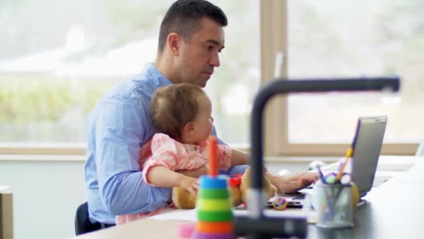 Πατέρας με το μωρό εργάζονται σε φορητό υπολογιστή στο γραφείο στο σπίτι — Αρχείο Βίντεο