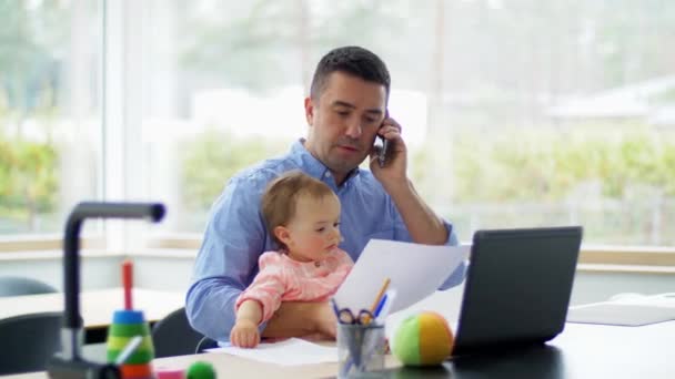 Πατέρας με μωρό καλώντας στο τηλέφωνο στο γραφείο στο σπίτι — Αρχείο Βίντεο