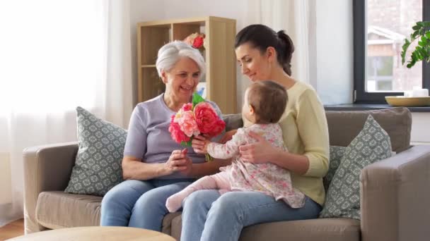 Madre e hija dando flores a la abuela — Vídeos de Stock