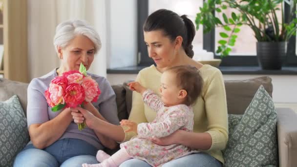 Мати і дочка дарують бабусі квіти — стокове відео