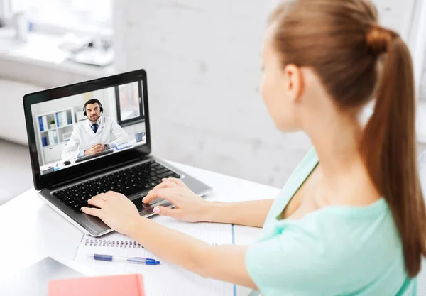 Frau telefoniert mit männlichem Arzt auf Laptop — Stockfoto