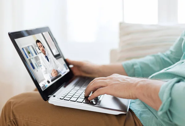 Homem tendo chamada de vídeo com médico masculino no laptop — Fotografia de Stock