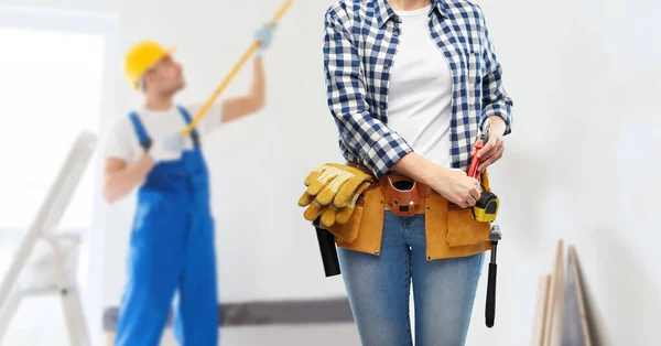 Kobieta lub budowniczy z narzędziami roboczymi na pasku — Zdjęcie stockowe