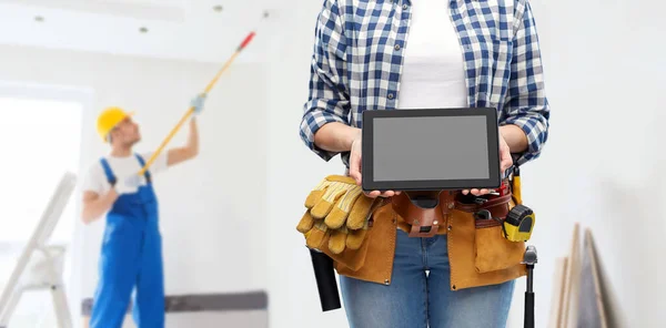 Bauarbeiterin mit Arbeitswerkzeug zeigt Tablet-PC — Stockfoto