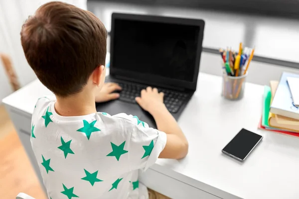 Μαθητής αγόρι δακτυλογράφηση σε φορητό υπολογιστή στο σπίτι — Φωτογραφία Αρχείου