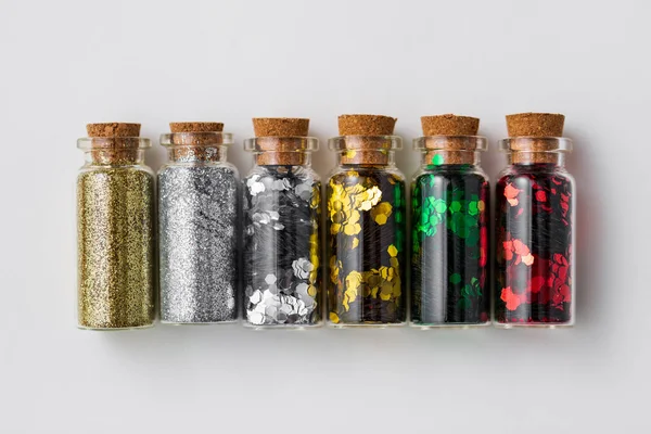 Set van glitters in flessen over witte achtergrond — Stockfoto