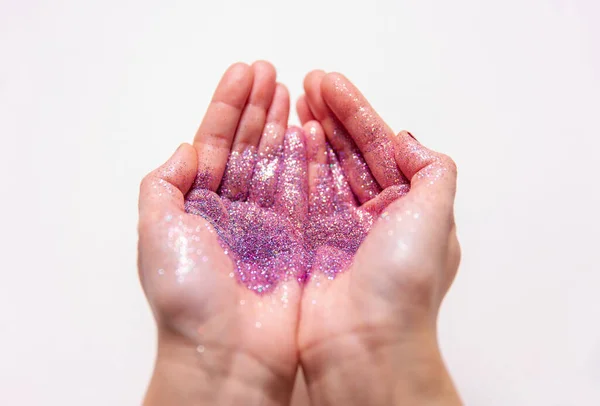 Händer som håller glitter på vit bakgrund — Stockfoto