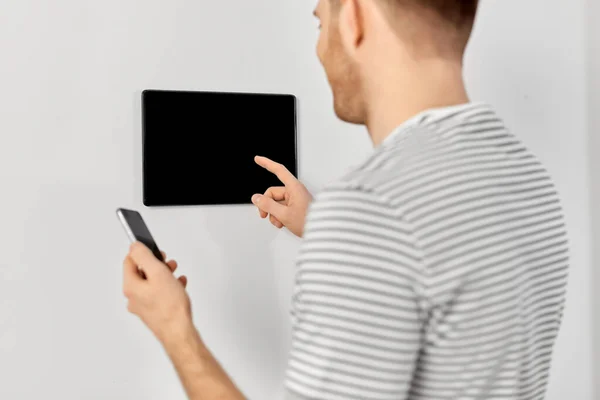 Homem com smartphone e tablet pc em casa inteligente — Fotografia de Stock