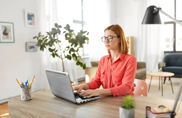 Жінка з ноутбуком працює в домашньому офісі — стокове фото